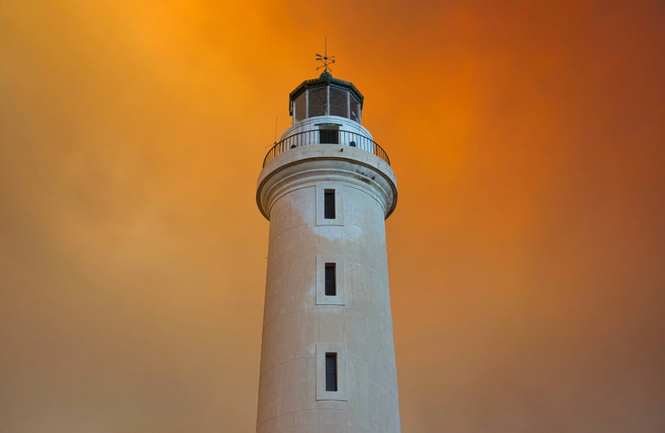 Il faro di Alessandropoli si staglia nel cielo arancione causato dai grandi incendi nell'area, nell'agosto del 2023