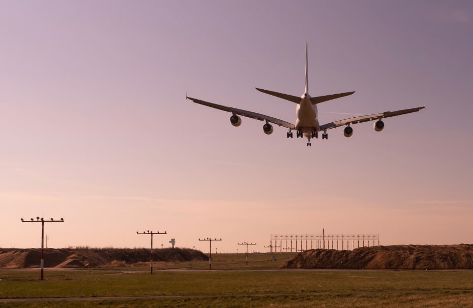 Un aereo in fase di atterraggio, visto da dietro, all'Aeroporto Internazionale di Dusseldorf durante l'alba o il tramonto